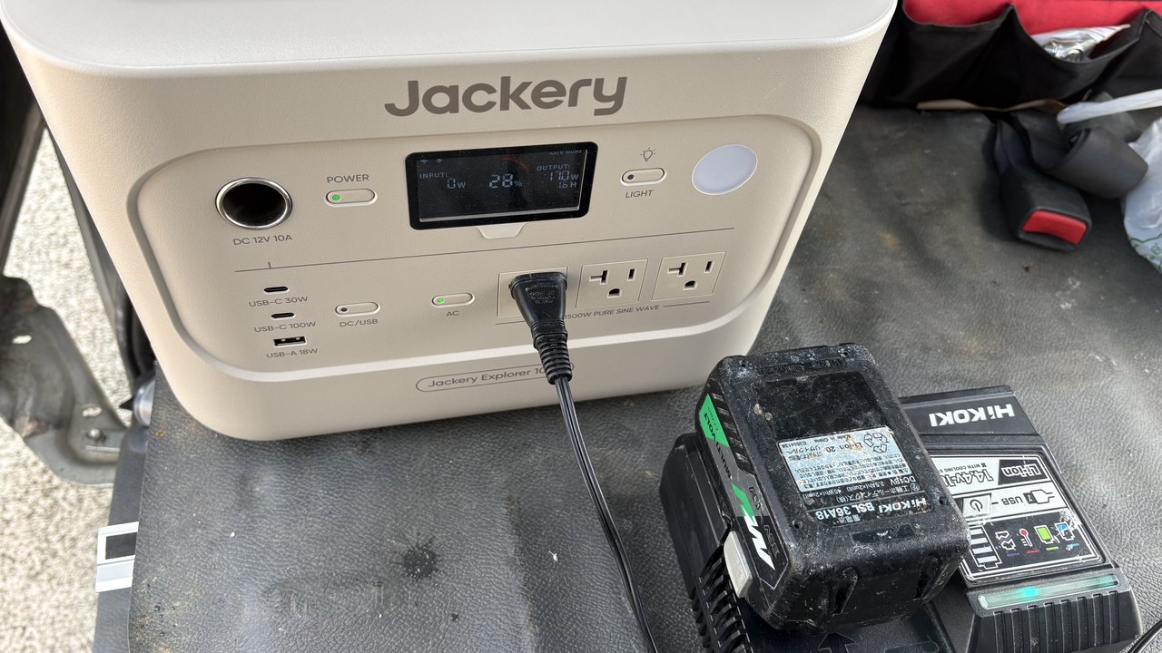 車内でポータブル電源から電動工具のバッテリーを充電する様子