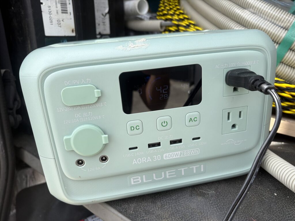 僕の手元のBLUETTI AORA 30 V2を正面から撮影。本体に600W・288Whの表記があり、ACコンセントから給電している