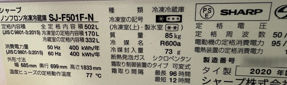 シャープの冷凍冷蔵庫 SJ-F501F-N の銘板。定格内容積502L、消費電力量は50Hz・60Hzとも400kWh/年、2020年製